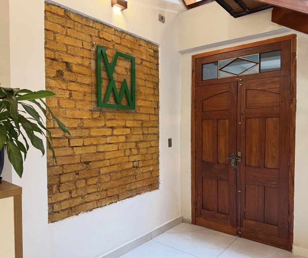 Entrada do escritório, com tijolos e símbolo Veiga Montemor